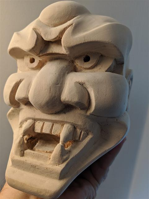 In-progress mask sculpture during intermediate shaping stage